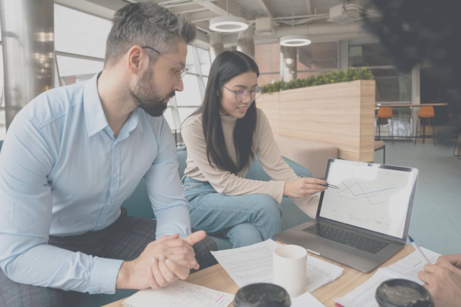 Profesionales trabajando con análisis financieros y pantallas de datos